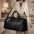Von Baer Weekender full-grain leather bag for women in black in a luxury interior, elegant travel bag for weekend trips.