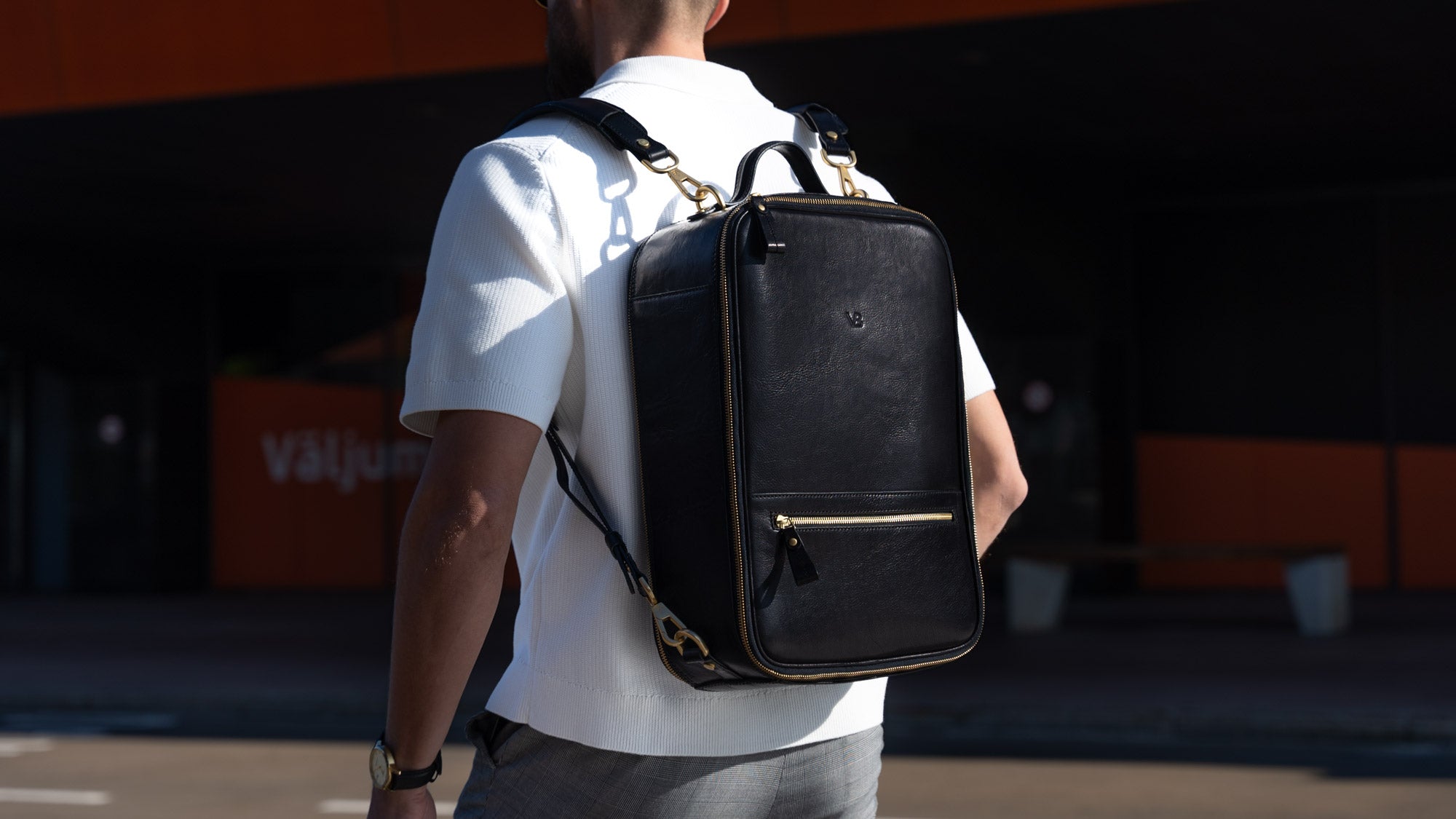Von Baer full grain luxury vegetable-tanned leather weekender travel bag in brown, held by a man in a car park