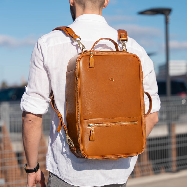 Von Baer 10X full grain vegetable-tanned leather backpack in tan on a male model in a car park