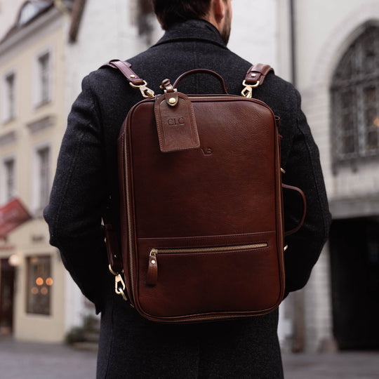 Von Baer 10x high-quality leather travel backpack in brown, perfect for carrying a camera, worn by a handsome man.