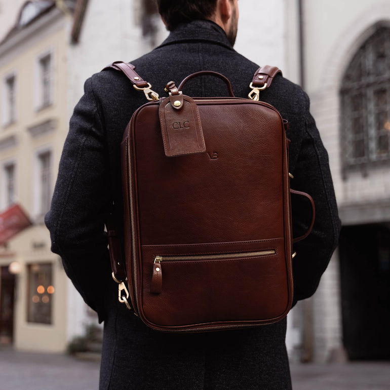 Von Baer 10x high-quality leather travel backpack in brown, perfect for carrying a camera, worn by a handsome man.