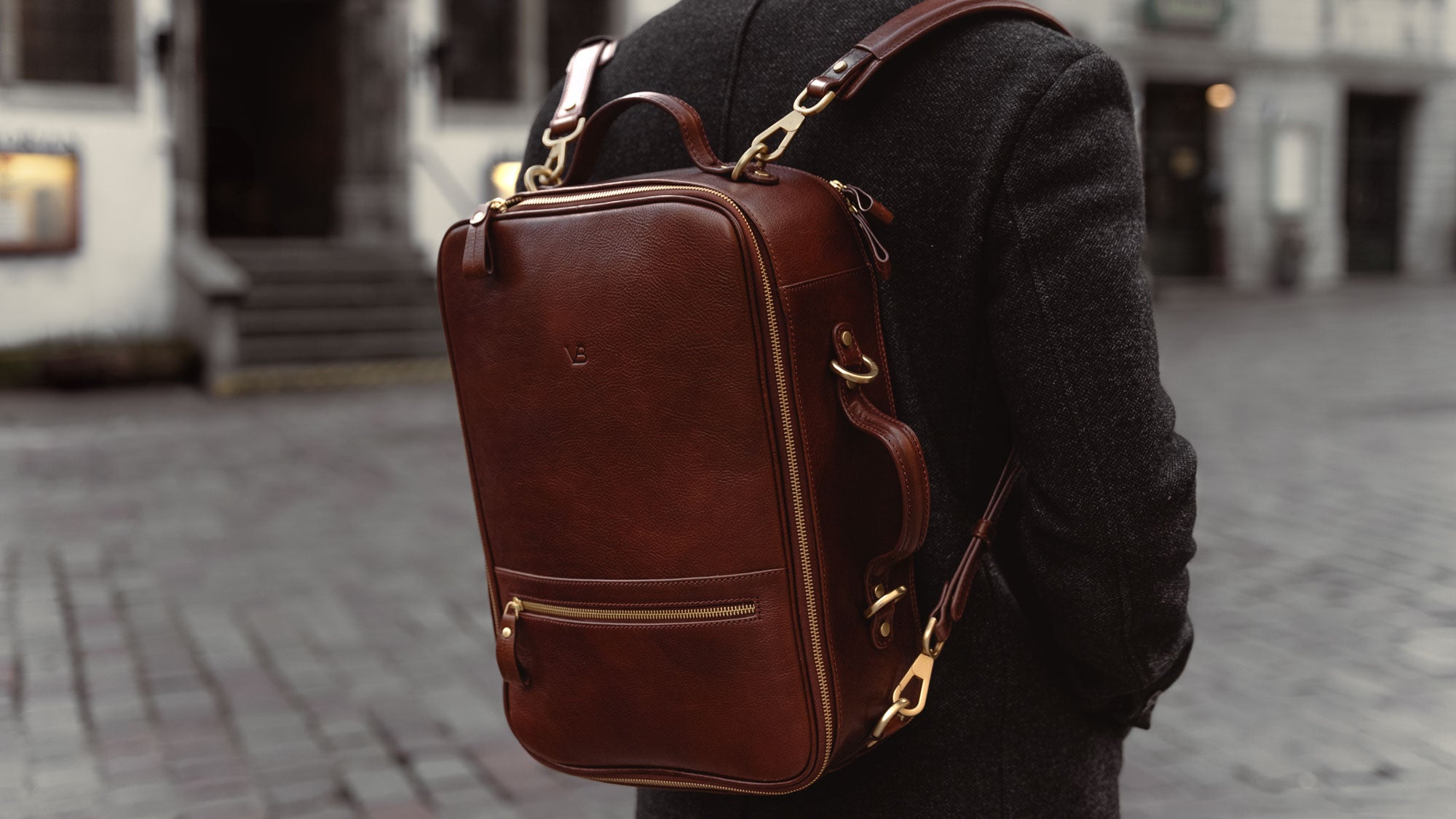 Von Baer 10x high-quality leather travel backpack in brown, multifunctional, worn in the old town, slider.