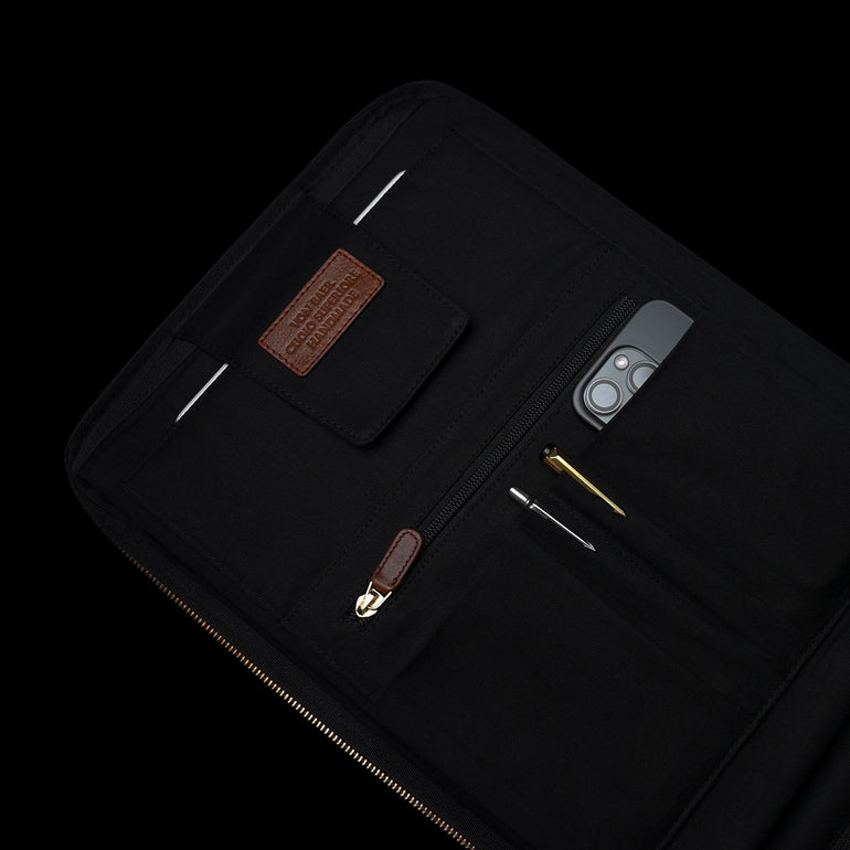 Von Baer 10x leather laptop travel backpack for men, MacBook compartment and pockets inside, filled with pens and iPhone.