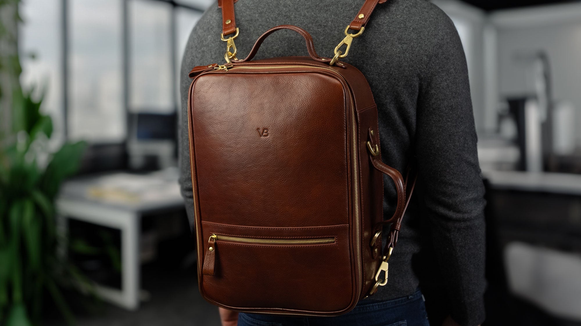 Von Baer 10x luxury leather laptop travel backpack in brown, worn in the office, slider.