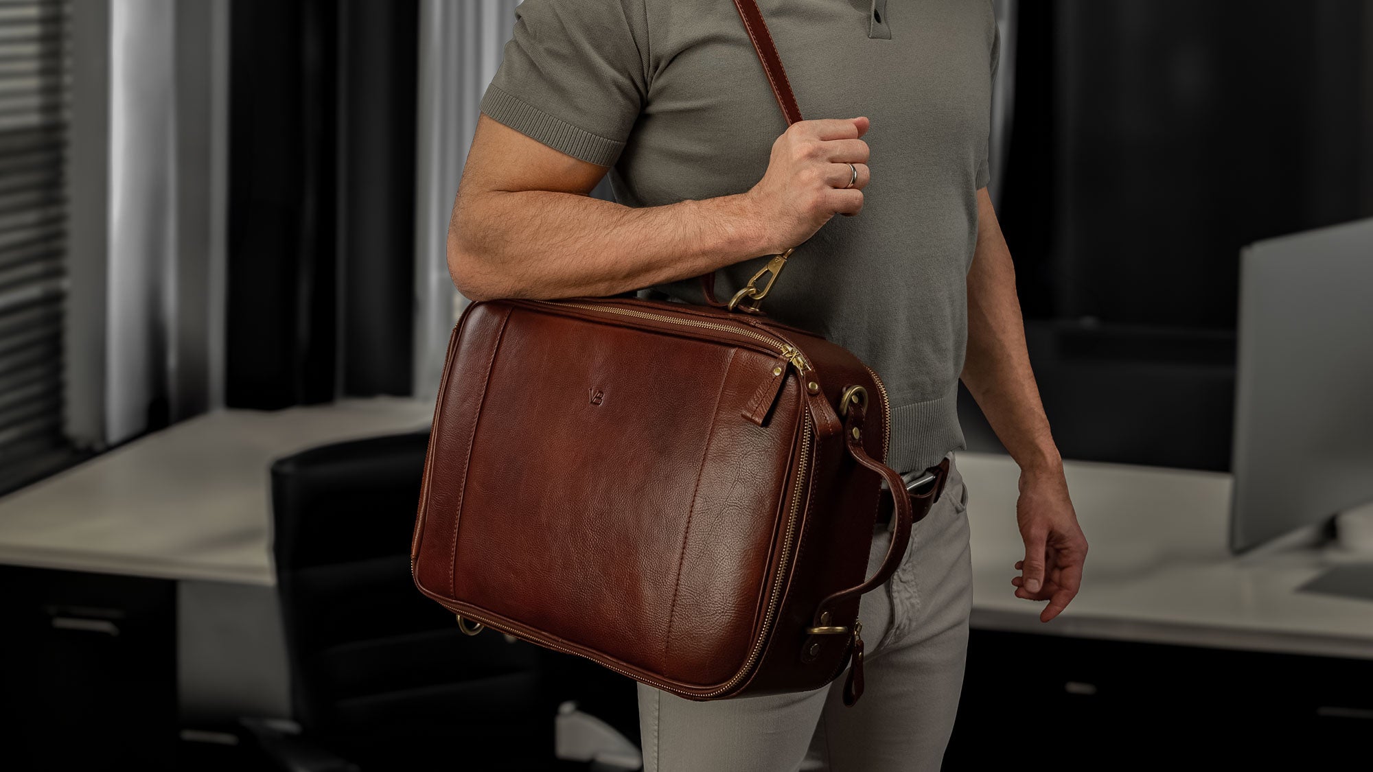 Von Baer 10x luxury leather laptop travel bag/briefcase with strap in brown, worn in the office, slider.