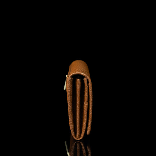 Von Baer Allure large cognac tan full-grain leather accordion wallet with RFID protection, shown in a back view highlighting the zipped outer pocket with a gold-tone zipper against a black background.