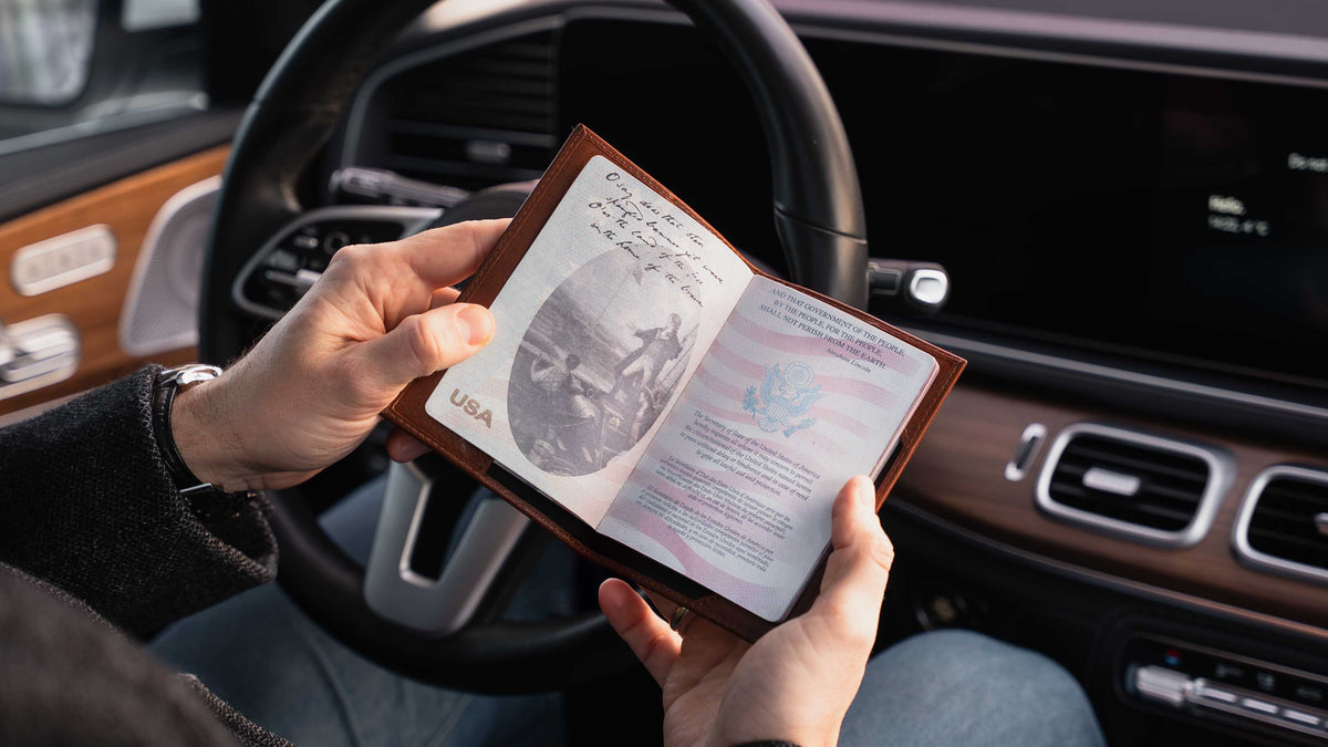 Von Baer Atlas full-grain leather passport holder in brown with US passport inside in a luxury car, travel accessory for professionals.