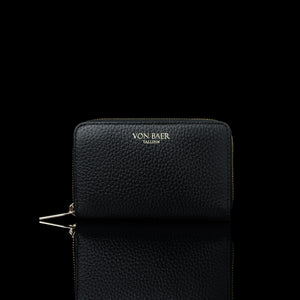 Von Baer Celeste small black full-grain leather zip-around wallet with gold-tone branding, displayed in a front view against a black background.