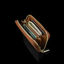 Von Baer Celeste small tan full-grain leather zip-around wallet shown filled with cards and dollar notes, featuring RFID protection, gold-tone zipper hardware, and gold-embossed Von Baer Tallinn branding against a black background.