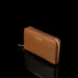 Von Baer Celeste small tan full-grain leather zip-around wallet shown in a side view on a black background, featuring RFID protection, gold-tone zipper hardware, and gold-embossed Von Baer Tallinn branding.