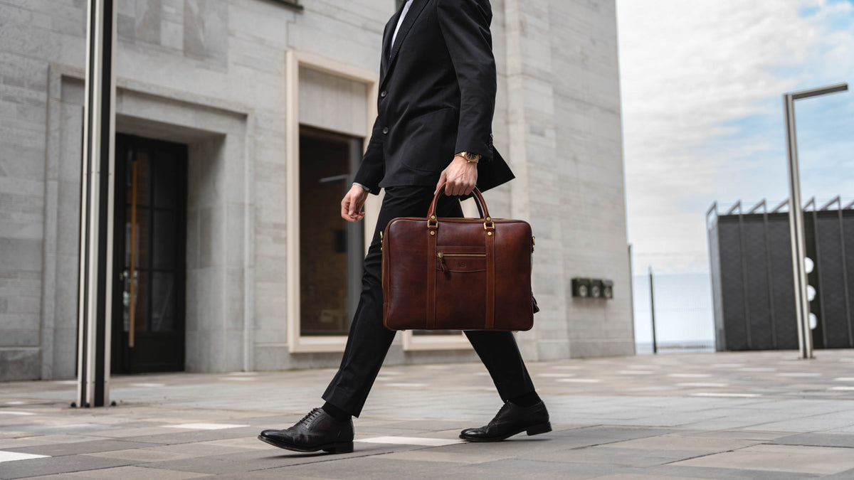 Von Baer City top luxurious large leather men's laptop bag for lawyers, carried by a male model, slider.