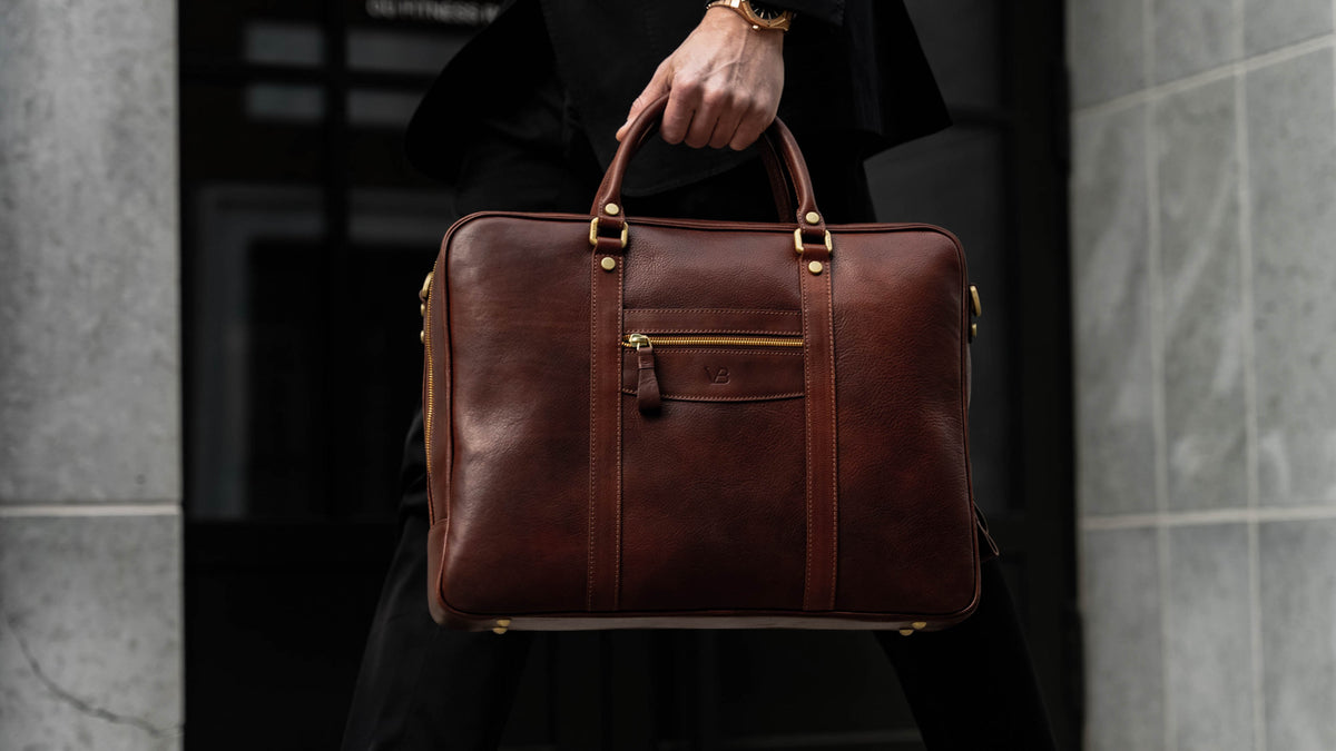 Von Baer City top luxurious large leather men's laptop bag for lawyers, carried by a man in a suit, slider.