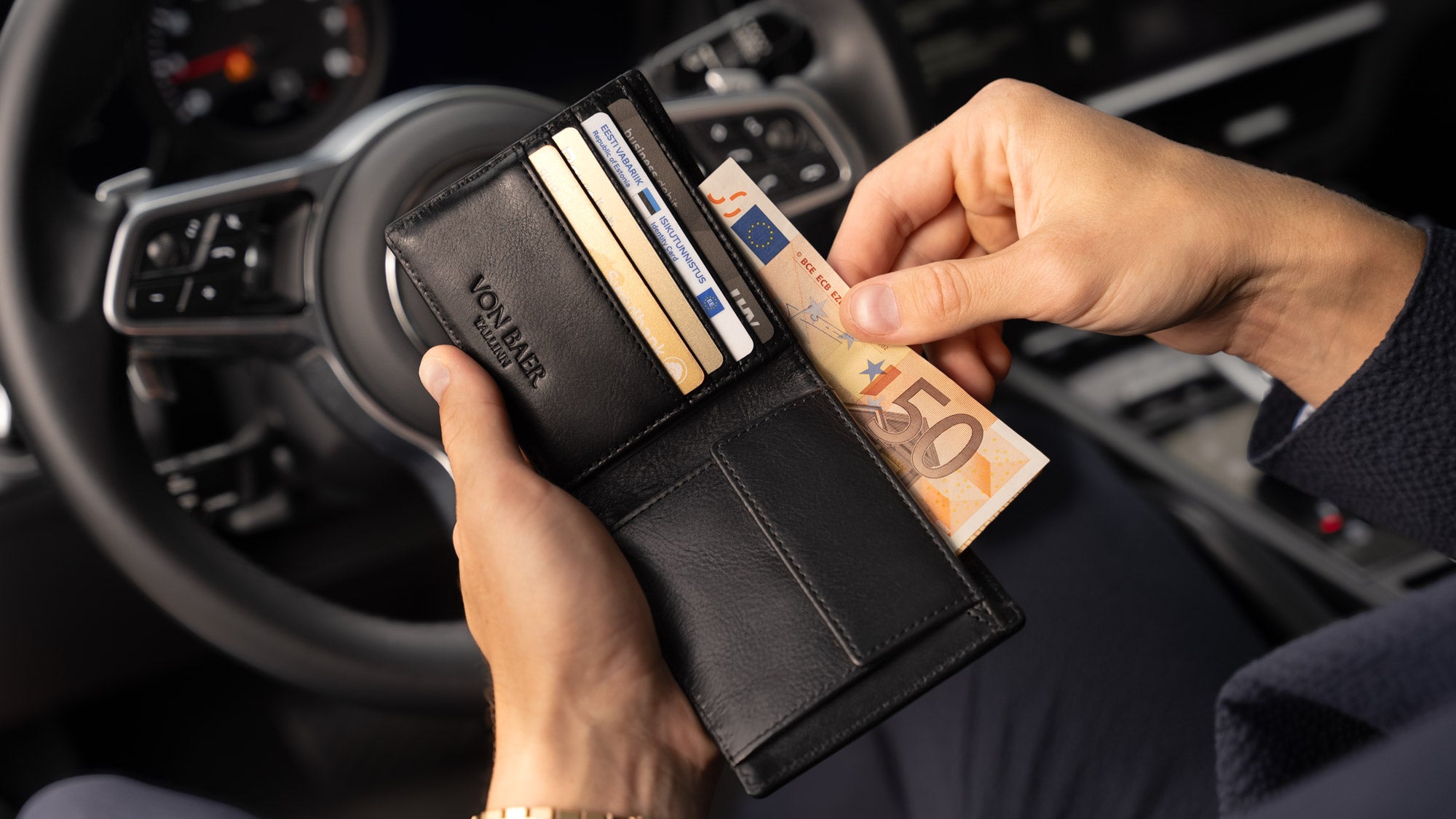 Von Baer Classic bifold luxurious black leather wallet filled with bank and credit cards, man taking out euro banknotes slider view