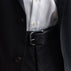 Von Baer classic luxury full-grain leather belt for men in black, with a buckle, worn with a black suit.