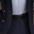 Von Baer classic luxury full-grain leather belt for men in black, with a buckle, worn with a navy blue suit.