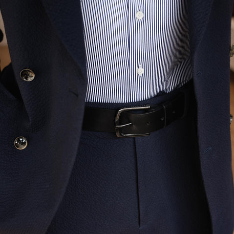 Von Baer classic luxury full-grain leather belt for men in black, with a buckle, worn with a navy blue suit.
