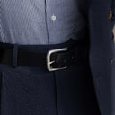 Von Baer classic luxury full-grain leather belt for men in black, with a silver stainless steel buckle, lifestyle shot.