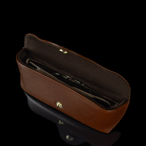 An upper view of a brown Von Baer Deluxe luxury leather glasses case with glasses inside.