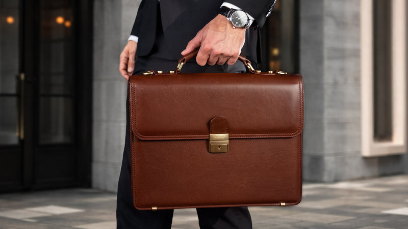 Von Baer diplomat brown full-grain leather men's classic briefcase, held by a man in a suit in a city setting, showcasing luxury and professional style