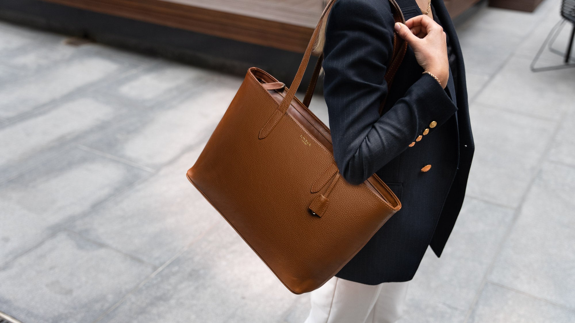 on Baer Elegance cognac tan leather tote bag showcased by female model outdoors, slider view