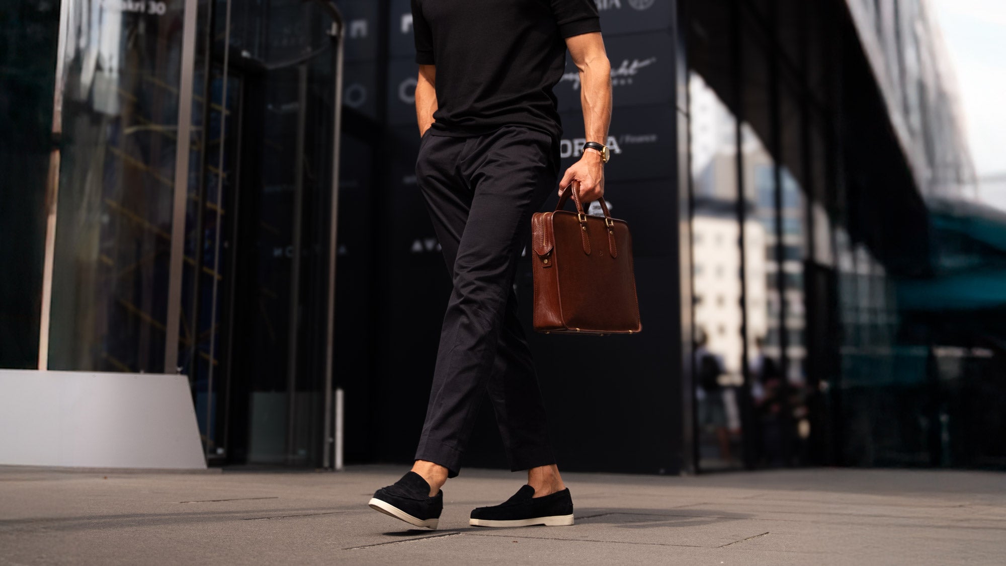 Man holding a slim brown Von Baer leather laptop bag