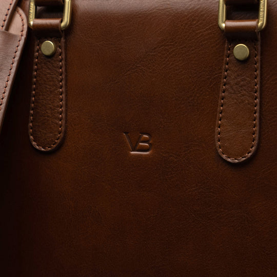 Men’s Von Baer Elegant high-quality slim full-grain leather laptop bag in brown, showcasing the VB logo close-up and leather texture.