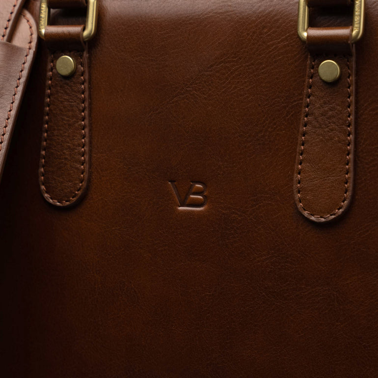 Men’s Von Baer Elegant high-quality slim full-grain leather laptop bag in brown, showcasing the VB logo close-up and leather texture.