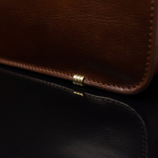 Men’s Von Baer Elegant high-quality slim full-grain leather laptop bag in brown, featuring protective metal feet close-up.