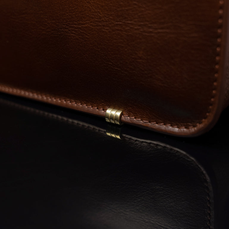 Men’s Von Baer Elegant high-quality slim full-grain leather laptop bag in brown, featuring protective metal feet close-up.