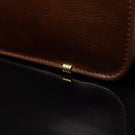 Von Baer Elegant high-quality slim full-grain leather women’s laptop bag in brown, close-up showing protective metal feet.