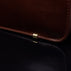 Von Baer Elegant high-quality slim full-grain leather women’s laptop bag in brown, close-up showing protective metal feet.