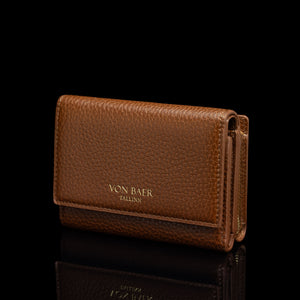 Von Baer Elise women's cognac pebbled leather trifold wallet shown from a three-quarter front view on a reflective black surface, featuring gold-embossed Von Baer Tallinn branding.