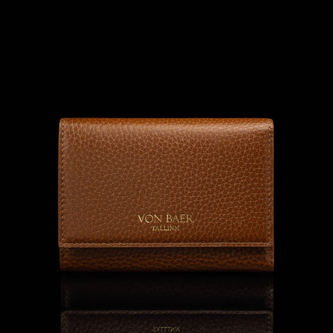 Von Baer Elise women's cognac pebbled leather trifold wallet shown in front view on a reflective black background, featuring gold foil Von Baer Tallinn branding.