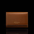 Von Baer Elise women's cognac pebbled leather trifold wallet shown in front view on a reflective black background, featuring gold foil Von Baer Tallinn branding.