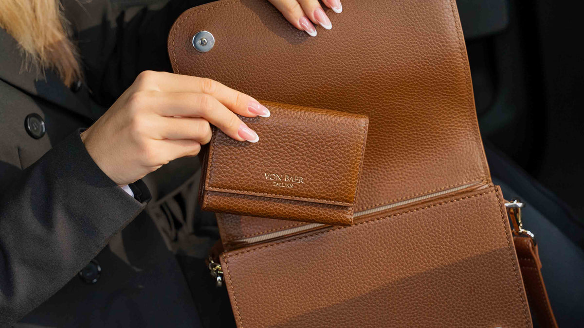 Von Baer Elise cognac tan women's leather wallet shown inside an open Isabella Grande large leather crossbody bag to display interior storage layout.
