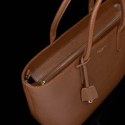 Von Baer Estelle brown leather tote bag for women with close-up view of the secure zip-top closure, pebbled leather texture and structured top handles.