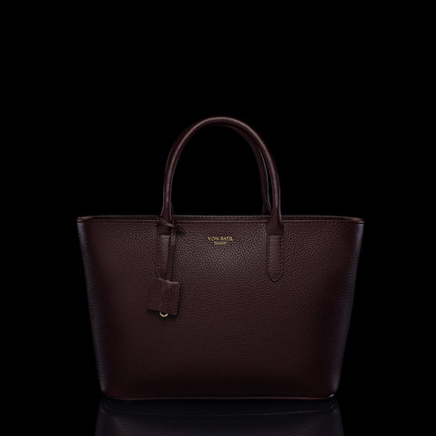 Von Baer Estelle burgundy small leather tote bag for women, shown from the front with structured top handles, pebbled leather texture, hanging clochette and gold-tone logo.