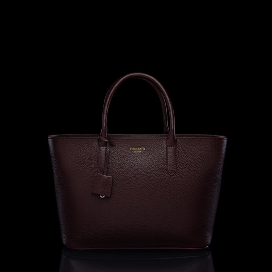 Von Baer Estelle burgundy small leather tote bag for women, shown from the front with structured top handles, pebbled leather texture, hanging clochette and gold-tone logo.
