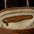 Von Baer Estelle brown small leather tote bag for women, showing the cream-lined interior with a leather-trimmed zipped pocket and gold-tone hardware.