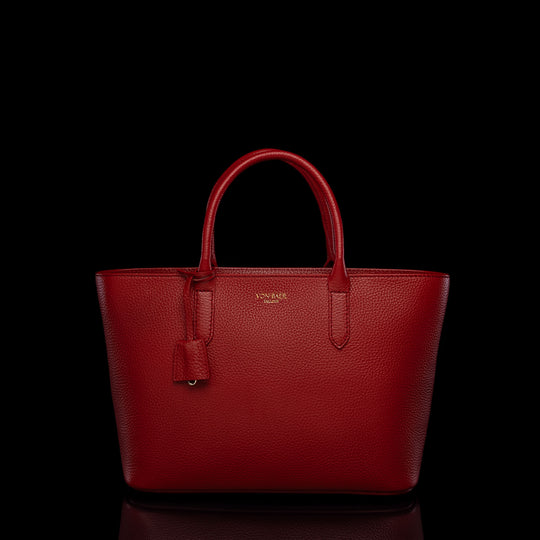 Von Baer Estelle red small leather tote bag for women, shown from the front with structured top handles, pebbled leather texture, hanging clochette and gold-tone logo.