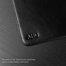 Von Baer black leather mat featuring custom initials embossing detail, showcasing personalized craftsmanship on a premium leather desk accessory.