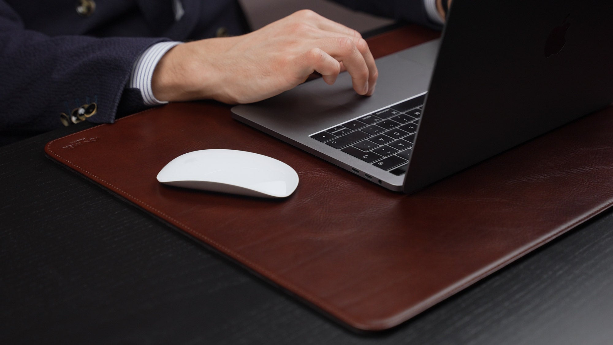 Von Baer Executive large brown leather desk pad and laptop mat used by businessman in suit working on MacBook 16x9