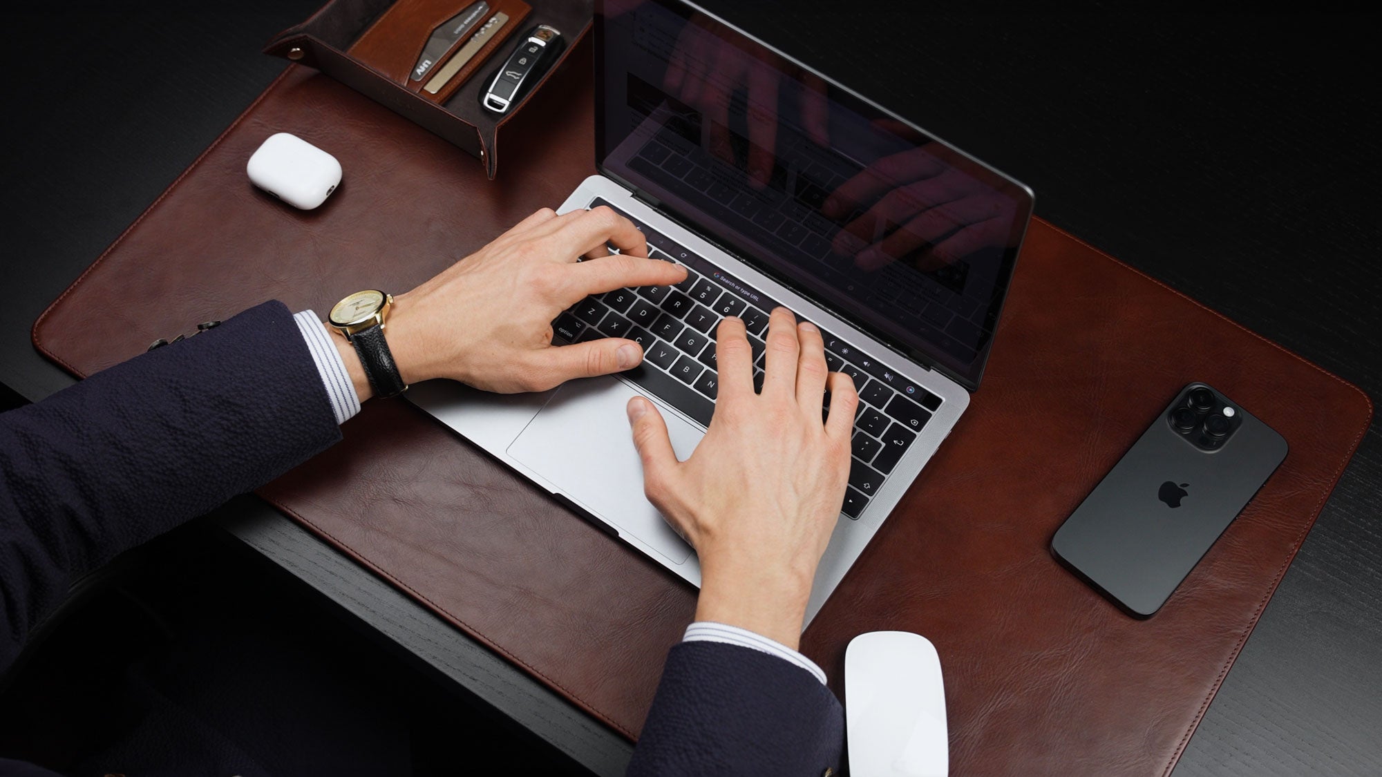 Von Baer Executive brown leather desk pad and laptop mat used by businessman in suit working on MacBook