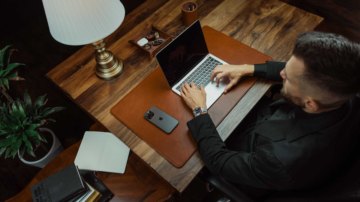Von Baer Executive tan leather desk pad with MacBook setup, man working in a luxury office, shown from an upper-view perspective
