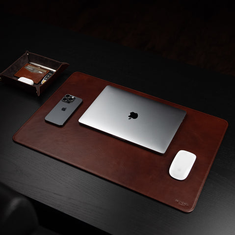 Von Baer executive luxury leather desk pad, brown, on a dark wood table with a MacBook, iPhone, mouse, and tray.