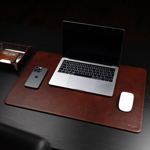 Von Baer Executive luxury leather desk pad in brown on a dark wood table with an open MacBook, iphone and mouse.
