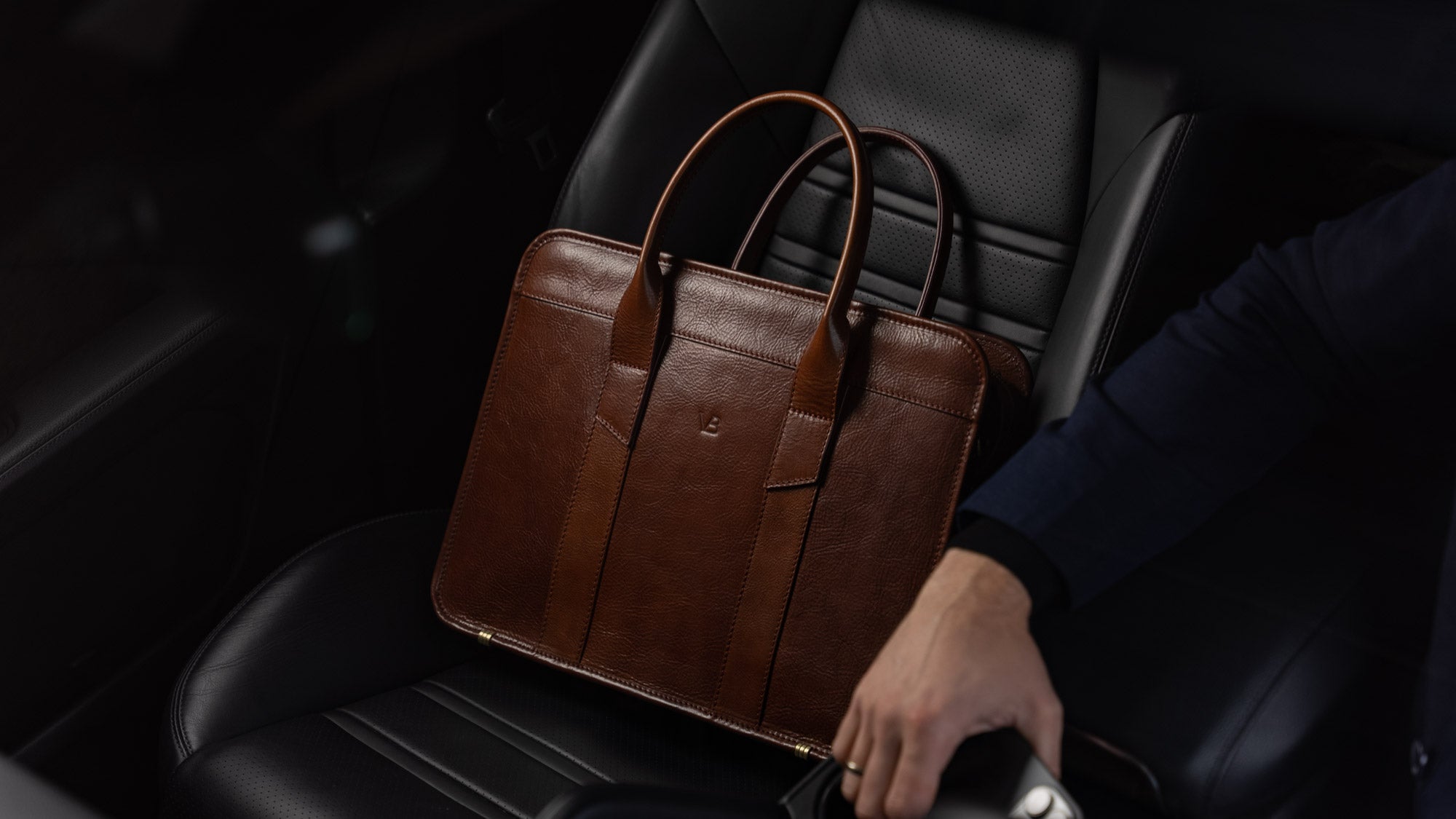 Von Baer Exquisite luxury slim full-grain leather laptop bag in the Porsche, near a male model, slider view.