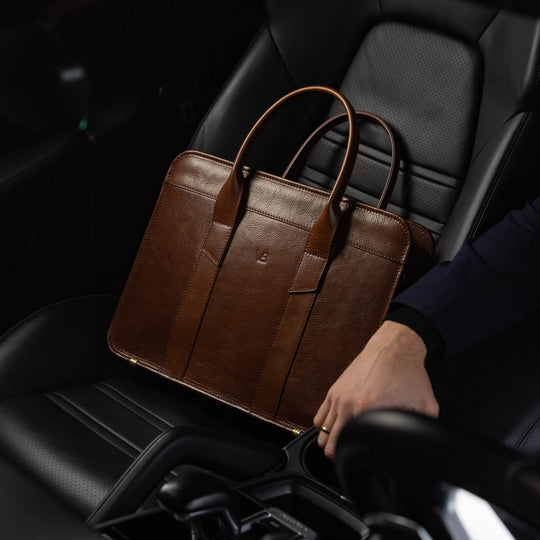 Men’s Von Baer Exquisite luxury slim full-grain leather laptop bag in the Porsche, near a male model.