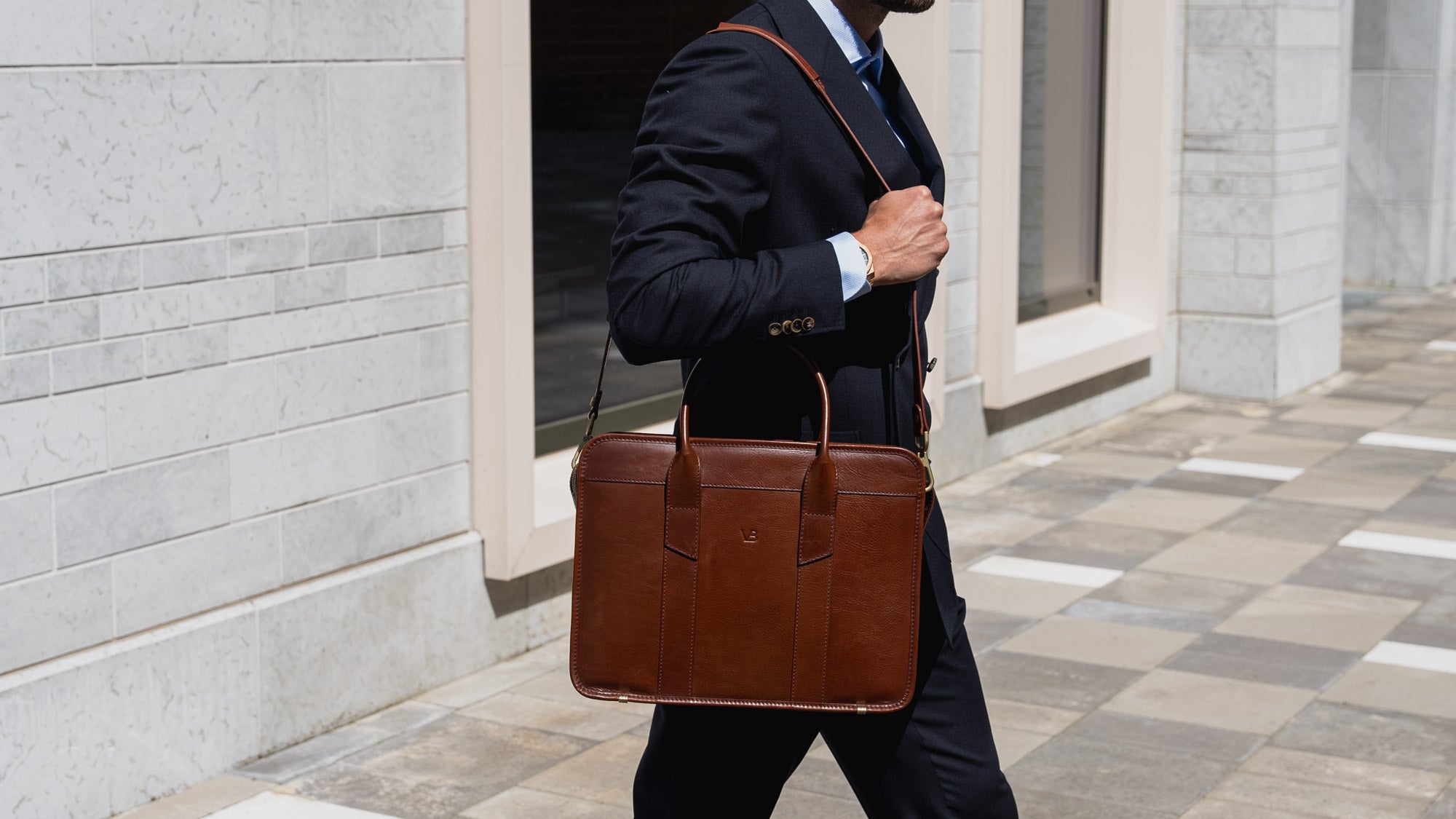 An exquisite, slim, brown Von Baer full-grain leather laptop briefcase with a shoulder strap