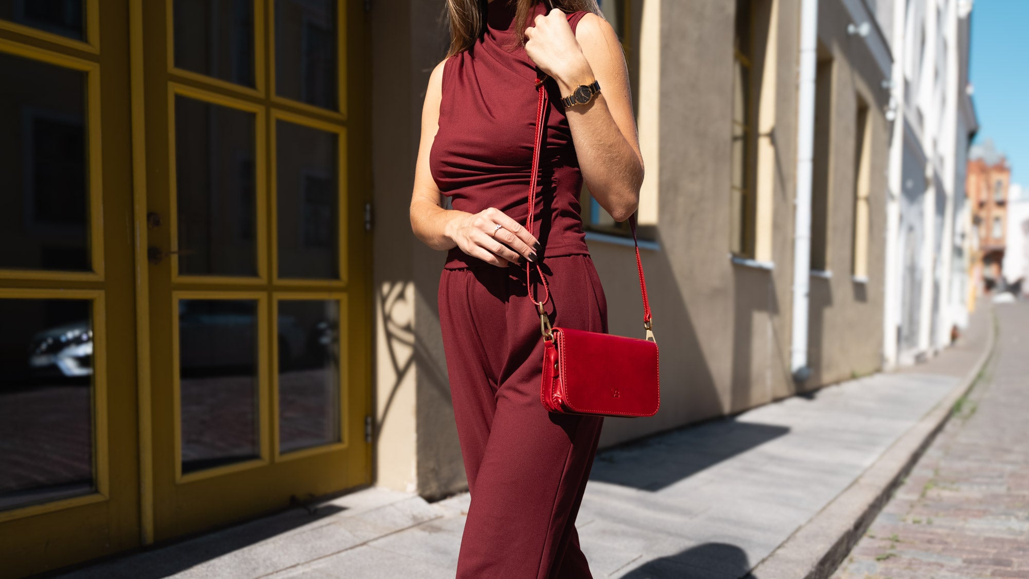 A female model holding a red Von Baer Isabella luxury leather women's handbag.